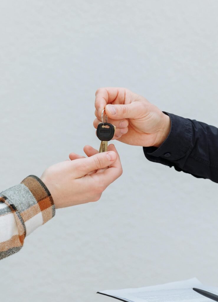 Close-up of hands exchanging car keys, symbolizing a business transaction.